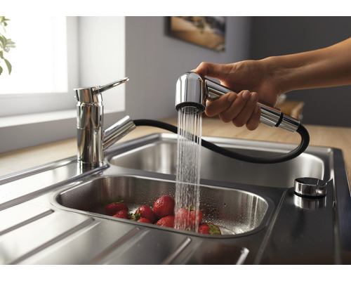 Spültischarmatur mit herausziehbarer Brause über einem Spülbecken mit Erdbeeren