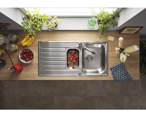 Edelstahlspüle mit Abtropffläche und Einbauspüle in einer hellen Küche.