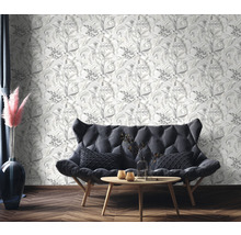 Wohnzimmer mit floral gemusterter Tapete, Sofa und Holztisch