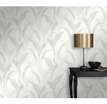 Raumansicht mit Tapete mit Blattmuster, Tisch und Lampe