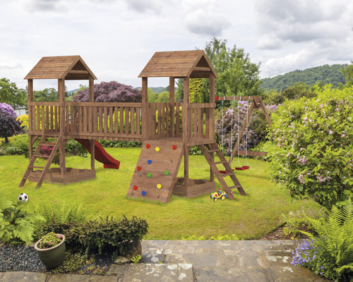 Kinderspielplatz aus Holz mit Schaukel, Rutsche und Kletterwand im Garten.