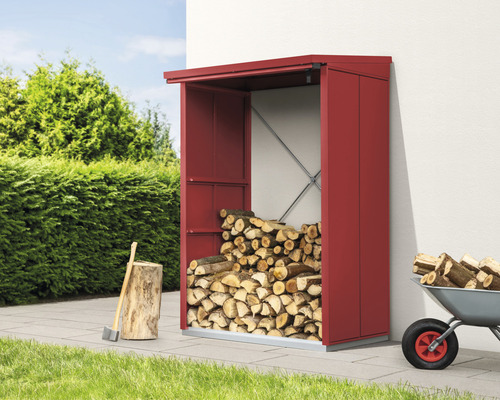 Holzlager mit gestapeltem Holz, Axt und Schubkarre im Garten