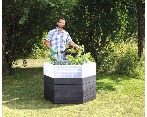 Hochbeet aus Holz mit Mann bei der Gartenarbeit im Garten