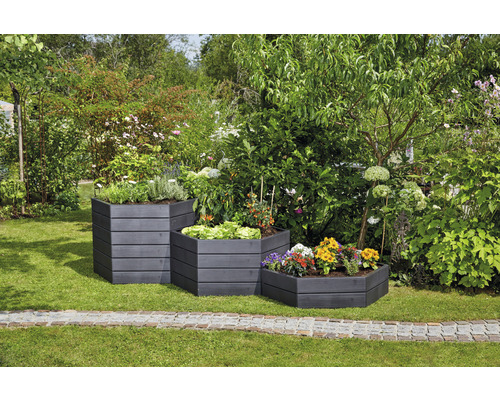 Drei gestufte, bepflanzte Hochbeete aus Holz im Garten.