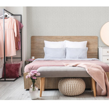 Schlafzimmer mit Bett, Kleiderständer, Kommode und Dekorationen für eine gemütliche Atmosphäre.