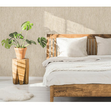 Schlafzimmer mit Holzbett, Pflanze im Topf auf einem Holzhocker und gemusterter Tapete