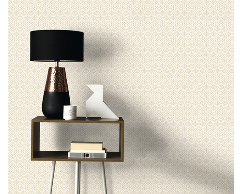 Dekorative Tapete mit geometrischem Muster hinter Tisch und Lampe.