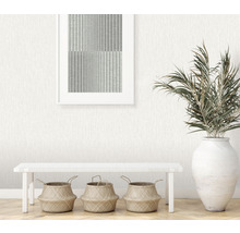 Dekoratives Interieur mit gemusterter Tapete, Bank, Körben und Pflanze im Topf