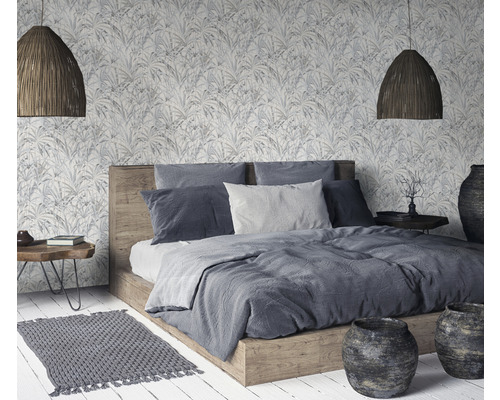Schlafzimmer mit Doppelbett, gemusterter Tapete, geflochtenen Lampen und Dekoration