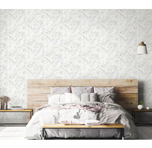 Schlafzimmer mit floraler Tapete, Holzbett und Nachttischen.