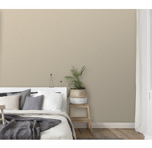 Schlafzimmer mit Bett, Zimmerpflanze und einfarbiger Tapete