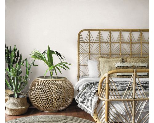 Schlafzimmer im Bohème Stil mit Bambusbett, Beistelltisch und Zimmerpflanzen