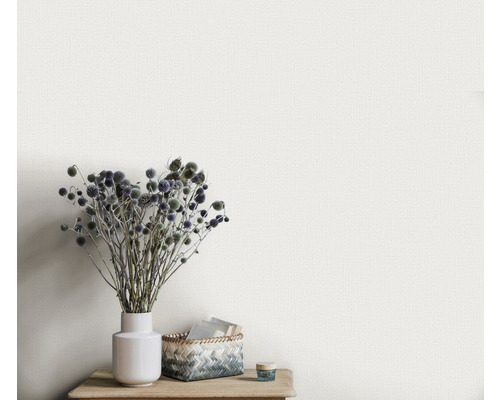 Nahaufnahme einer strukturierten Tapete mit Vase und Dekoration auf einem Holztisch