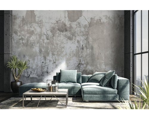 Wohnzimmer mit modularem Sofa, Couchtisch und Zimmerpflanzen vor einer Betonwand