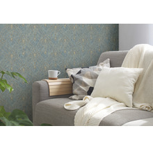 Wohnzimmer mit grauer Couch, Kissen, Decke, Beistelltisch mit Tasse und gemusterter Tapete