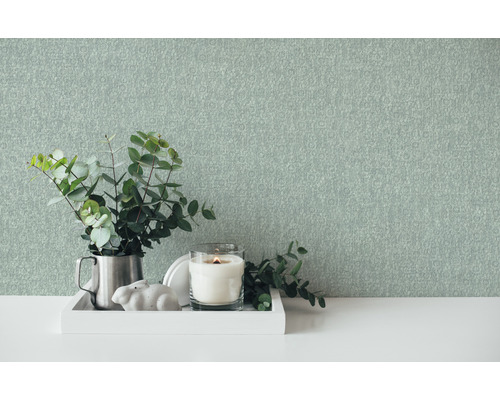 Dekorative Szene mit Tapete, Kerze und Pflanze auf einem Tisch