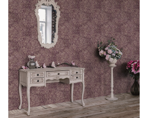 Dekorative Szene mit Ornamenttapete, Schminktisch, Spiegel und Blumenarrangements für ein elegantes Ambiente.