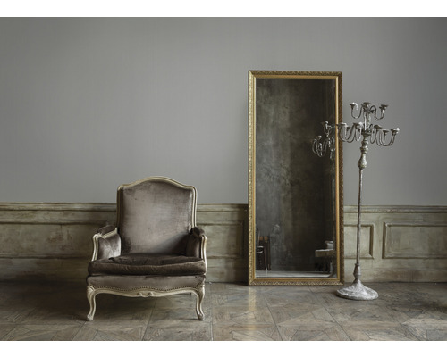 Sessel, Spiegel und Kerzenständer in einem Zimmer im Vintage-Stil