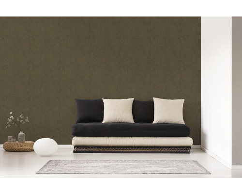 Wohnzimmer mit dunkelbrauner Tapete, Sofa mit Kissen und Teppich