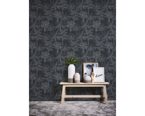 Szene mit einer Wandtapete mit Palmenmuster, einem Holztisch, Vasen und Dekorationsartikeln.