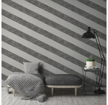 Raum mit gestreifter Tapete, Sessel, Hocker und Stehlampe