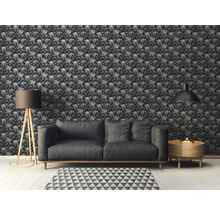 Dekoriertes Zimmer mit gemusterter Tapete, Sofa, Lampe und Beistelltisch