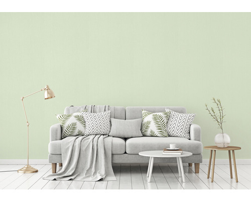 Wohnzimmer mit Couch, Kissen, Tisch und Stehlampe