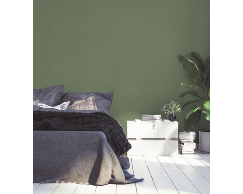 Schlafzimmer mit Bett, Nachttisch und grüner Wand