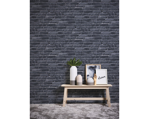 Dekorative Steinoptik Tapete über einem Tisch mit Vasen und Bildern.