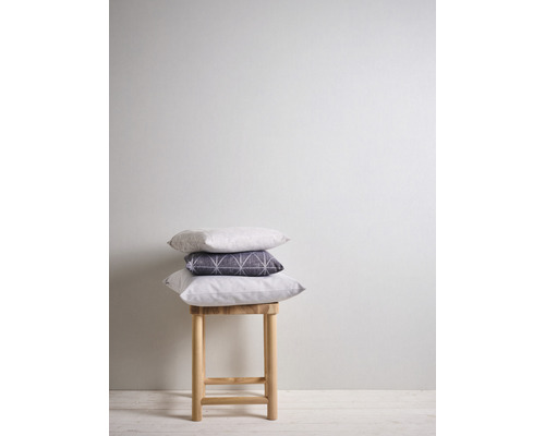 Stapel von drei Kissen auf einem Holzhocker