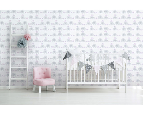 Kinderzimmer mit Elefantenmuster-Tapete, Leiter, Sessel und Babybett.