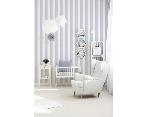 Babyzimmer mit gestreifter Tapete, Kinderbett und Sessel