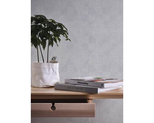 Dekorative Tapete mit geometrischem Muster im Wohnraum mit Pflanze und Büchern