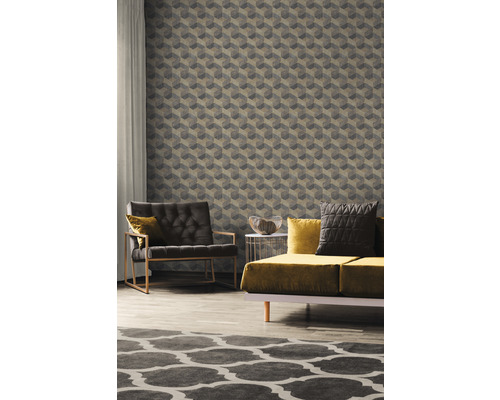 Wohnzimmer mit Sessel, Sofa und geometrischer Tapete