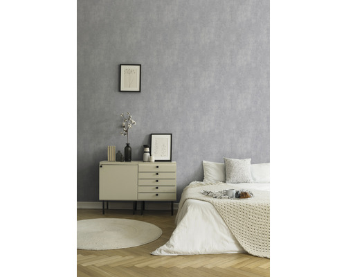 Helles Schlafzimmer mit grauer Tapete, Kommode und Bett