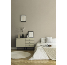 Schlafzimmer mit Bett, Kommode, runden Teppich und Dekoration
