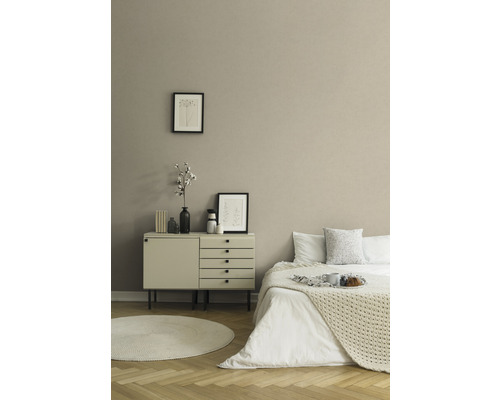 Schlafzimmer mit Bett, Kommode, runden Teppich und Dekoration