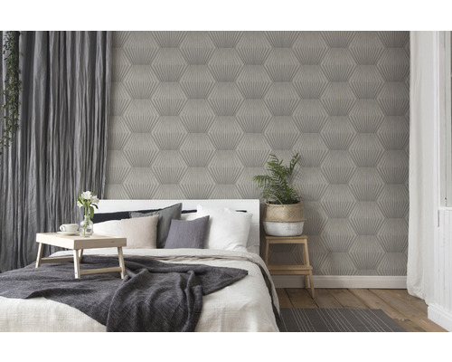 Schlafzimmer mit Bett vor einer Wand mit Tapete mit geometrischem Muster