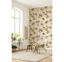 Heller Raum mit floraler Tapete, rundem Sessel und Zimmerpflanzen