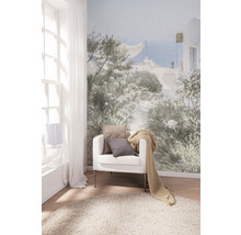 Wohnzimmer mit Fototapete, Sessel, Kissen, Tagesdecke und Teppich für eine helle und freundliche Atmosphäre.