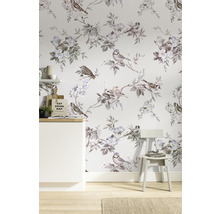 Raum mit Vogel- und Blumenmustertapete, einem weißen Schrank und einem Stuhl.