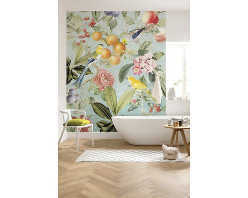 Badezimmer mit Badewanne und Wandtapete mit Vogel-, Blumen- und Fruchtmotiven für ein helles und freundliches Ambiente.
