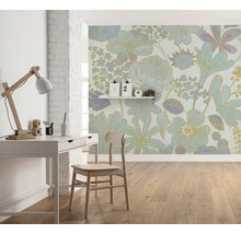 Ein Zimmer mit einem Schreibtisch, einem Stuhl und einer floralen Tapete.