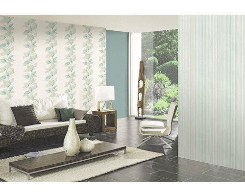 Wohnzimmer mit floraler Tapete, Sofa, Tisch und Sessel.