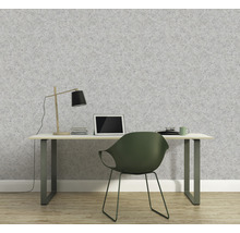 Ein Arbeitszimmer mit einem Schreibtisch vor einer grauen Tapete.