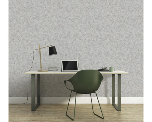 Ein Arbeitszimmer mit einem Schreibtisch vor einer grauen Tapete.