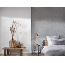 Schlafzimmer mit Bett, Nachttischlampe und Dekoration auf einem Holztisch.