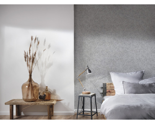 Schlafzimmer mit Bett, Nachttischlampe und Dekoration auf einem Holztisch.