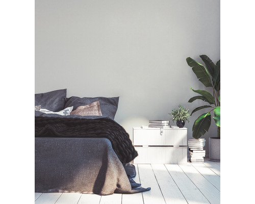 Schlafzimmer mit Bett, Nachttisch und Zimmerpflanzen.