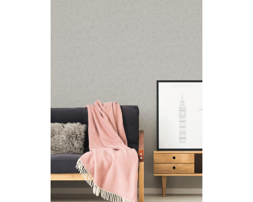 Wohnszene mit Tapete, Sofa, Kissen, Decke, Bild und Kommode